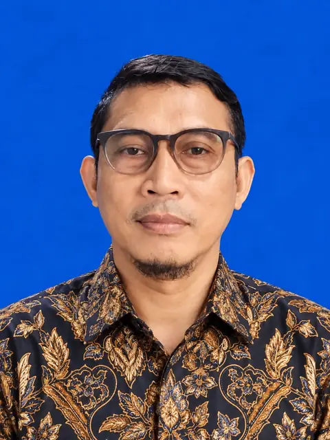 Andri Juliono mengenakan kemeja batik dan kacamata