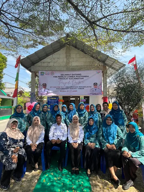 Kelompok warga berfoto di halaman dengan pepohonan