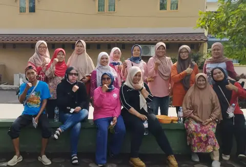 Warga berfoto di depan bangunan lingkungan