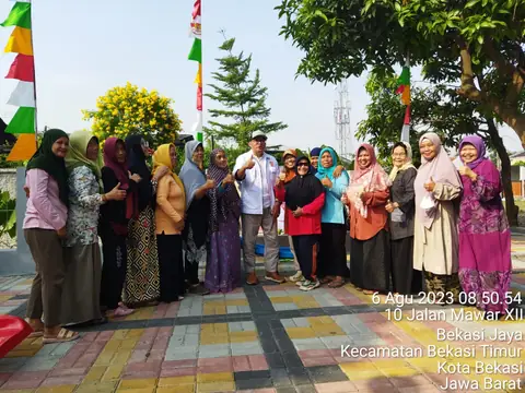 Warga berfoto di halaman dengan bendera merah putih